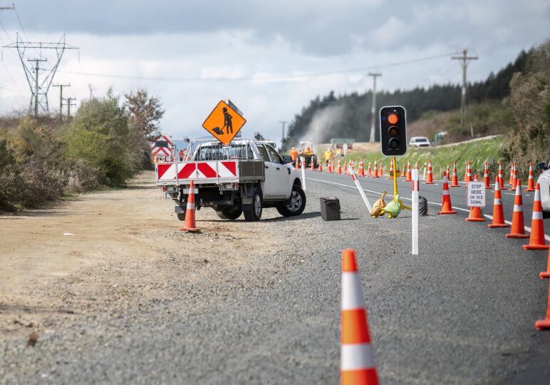 Road construction scene with traffic cones and sign.